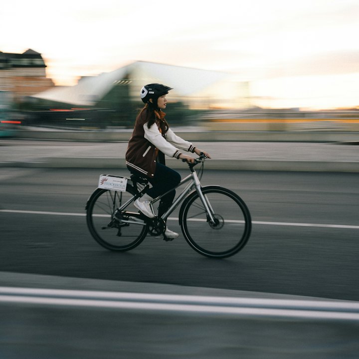 A woman riding a city bike along a street at dusk