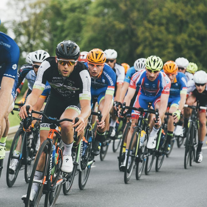 A group of road cyclists riding close together on asphalt