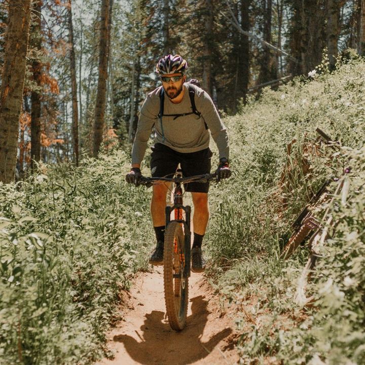 A mountain biker on a narrow singletrack through the woods